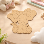 MDF DIY elephant cutout on a wooden surface with soft toys and books in the background