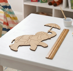 MDF DIY elephant cutout on a white table with a ruler and paintbrush