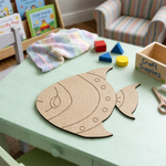 MDF DIY fish cutout on a ligh green table.