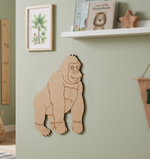 MDF DIY gorilla wall decoration on a light green wall with children's books below.