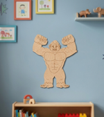 MDF DIY wall decoration of a muscular figure on a blue wall with children's toys and books below.
