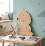 DIY MDF  penguin decoration on a table in a child's room with toys and books.
