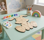 Children's art supplies including DIY MDF  animal shapes, paint, and brushes on a table.
