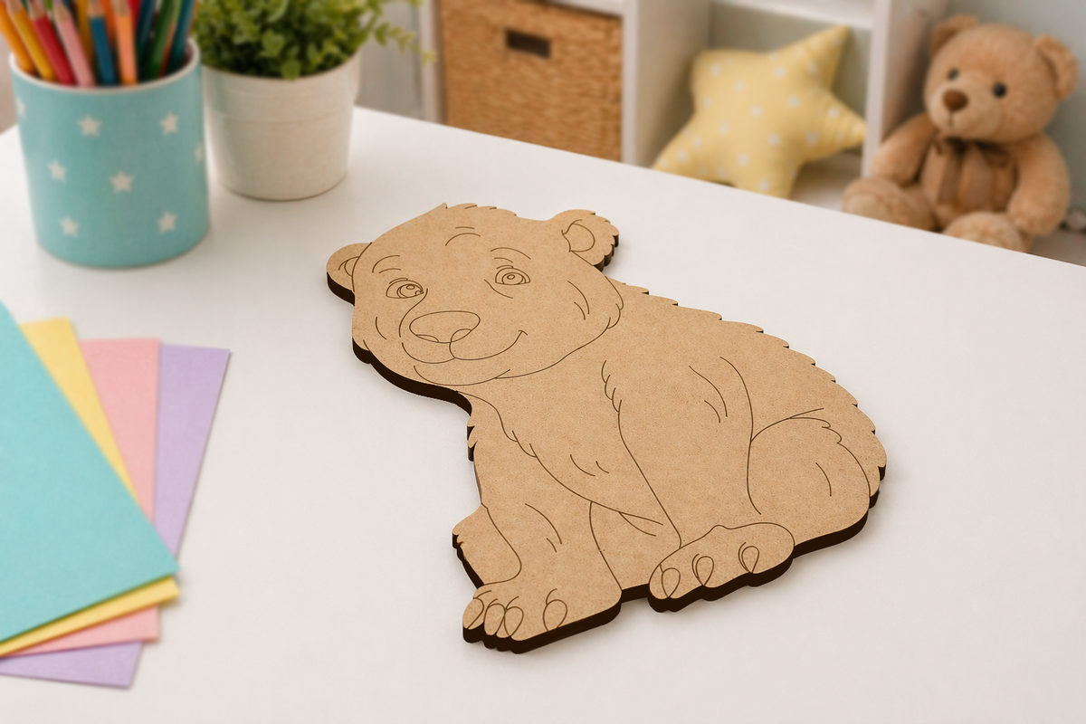 DIY MDF  bear-shaped cutout on a table with colorful paper and a teddy bear in the background