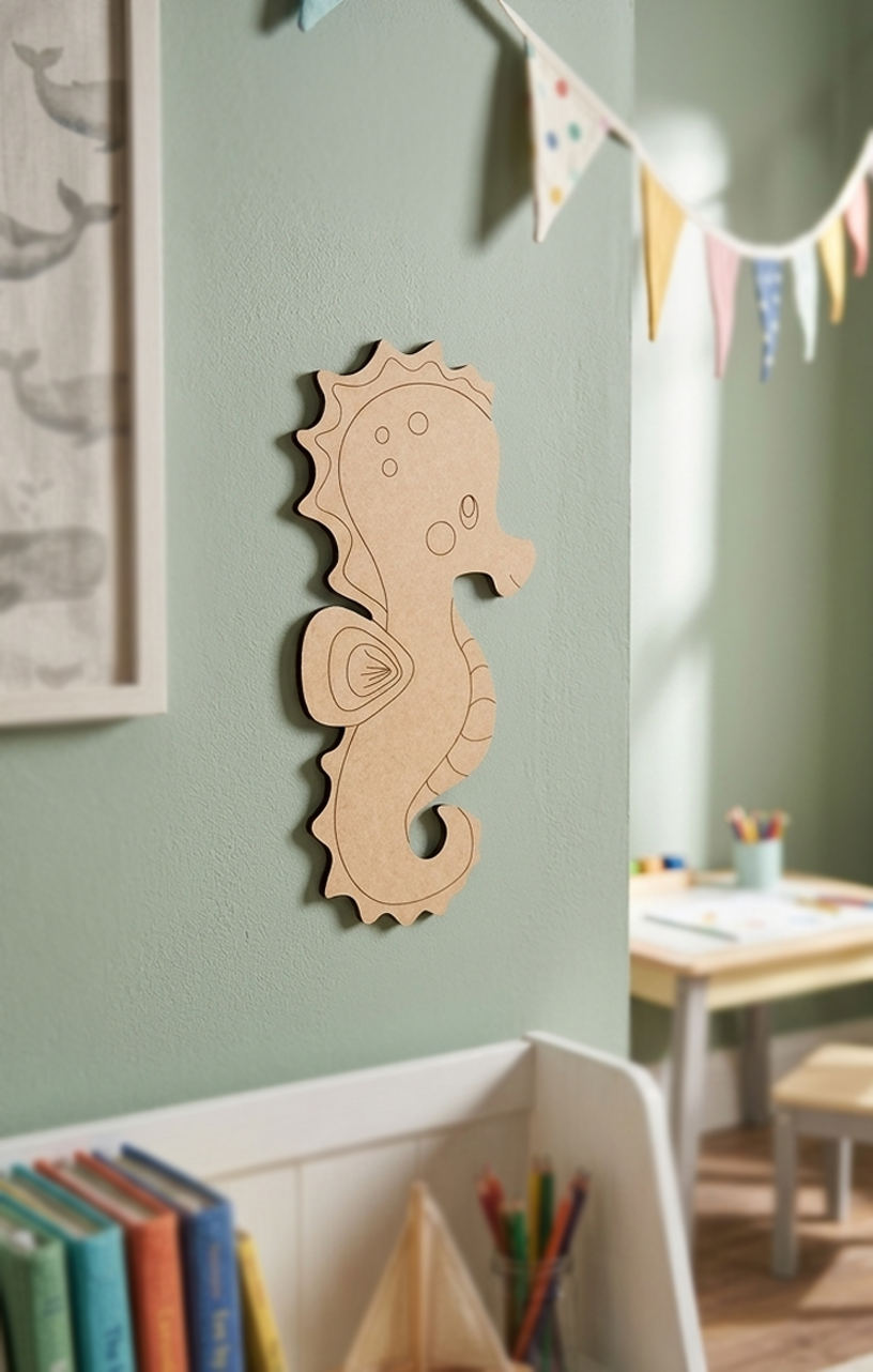 DIY MDF  seahorse decoration on a light green wall with books and a table in the background