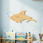 DIY MDF  shark cutout on a wall with children's books and toys below