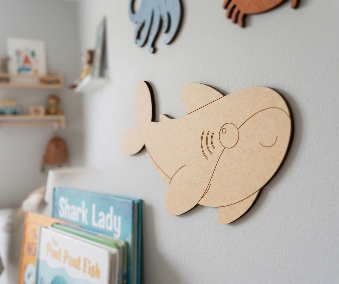 DIY MDF  shark cutout on a wall with children's books below