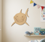 DIY MDF  shark cutout on a wall with children's books and toys below