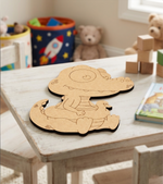 MDF DIY cutout of a child with a teddy bear on a table in a child's room.