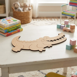MDF DIY  alligator cutout on a table with children's books and blocks in a room.