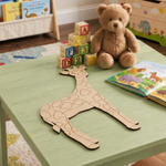 MDF DIY  giraffe cutout on a child's table with toys and books in the background