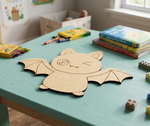 DIY MDF  bat-shaped cutout on a table with coloring books and crayons in a child's room.