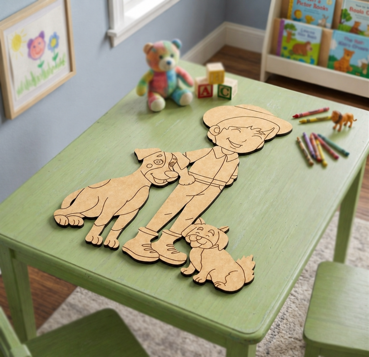MDF DIY cutouts of a boy and his dog on a green table with toys and books in the background.