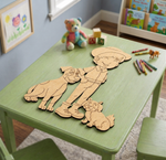 MDF DIY cutouts of a boy and his dog on a green table with toys and books in the background.