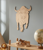 MDF DIY bull wall decoration on a gray wall with wooden toys and a globe in the foreground.