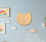 MDF DIY cat face cutout on a wall with toys .