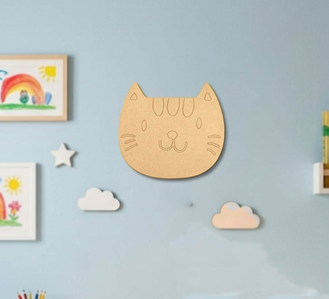 MDF DIY cat face cutout on a wall with toys .