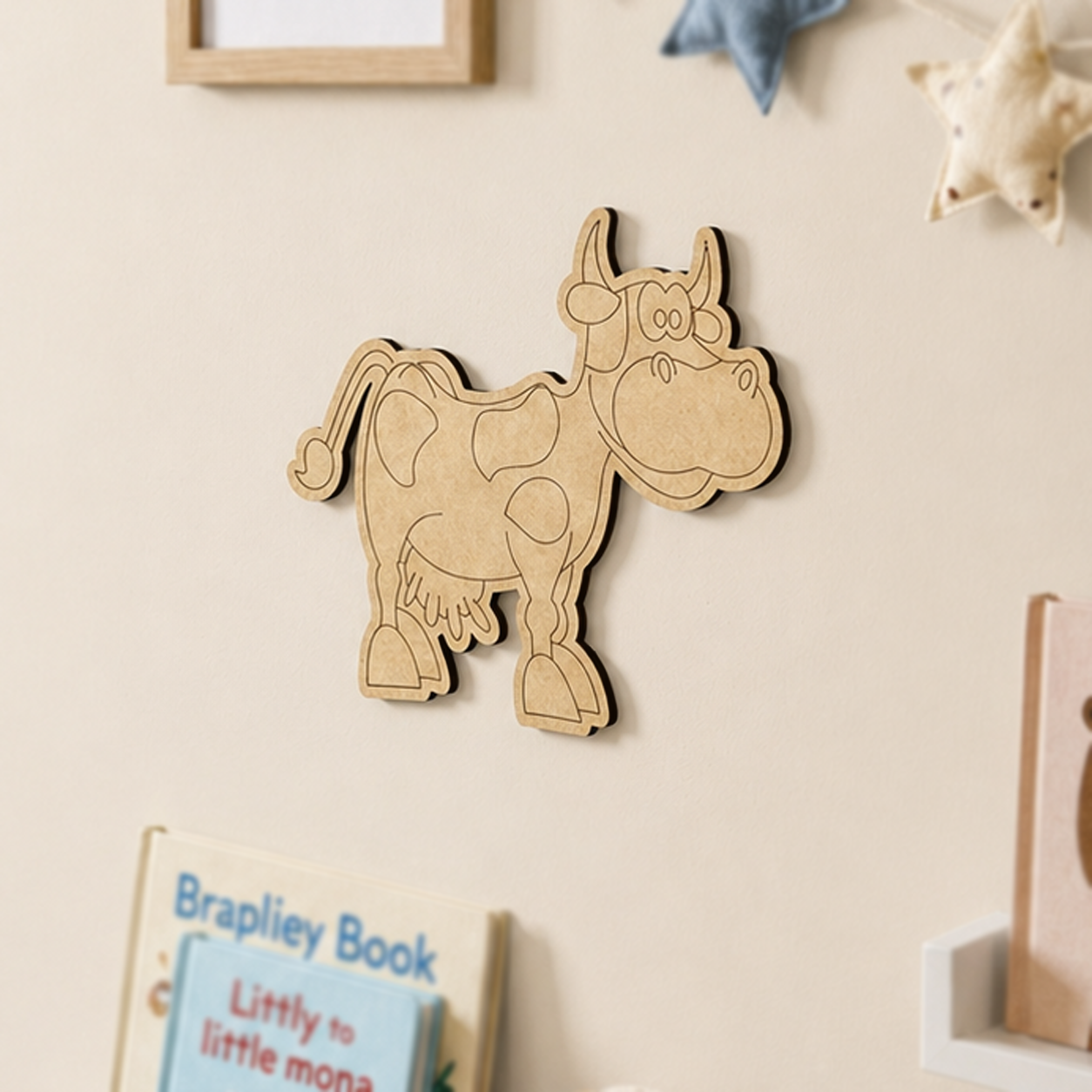 MDF DIY cow wall decoration on a beige wall with books below