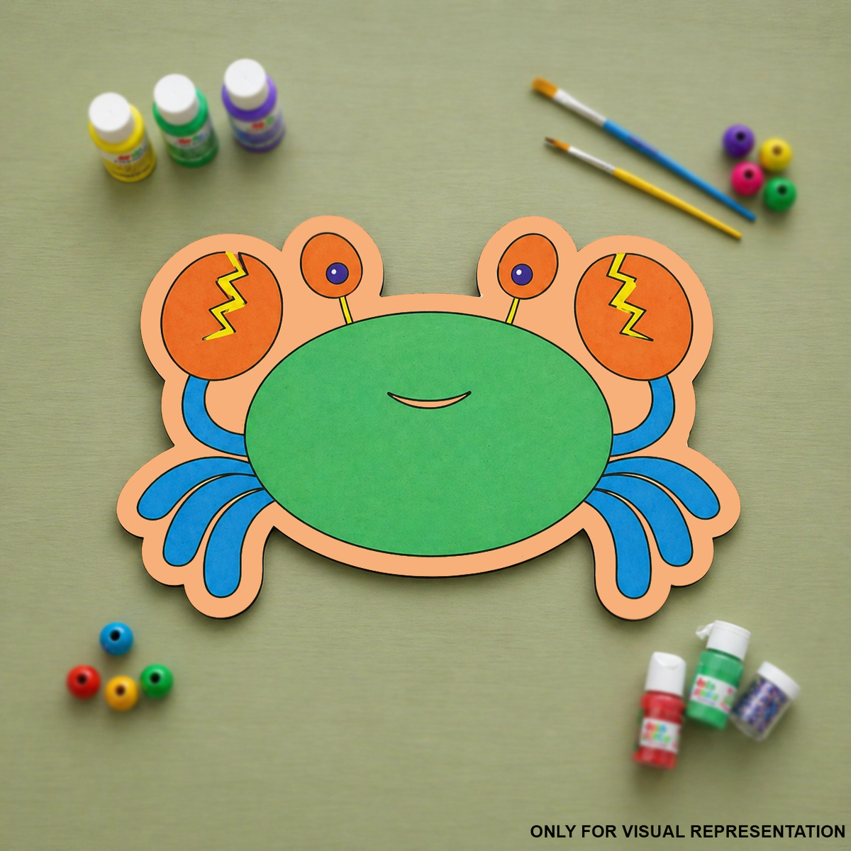 Colorful MDF DIY crab craft with painting supplies on a green background