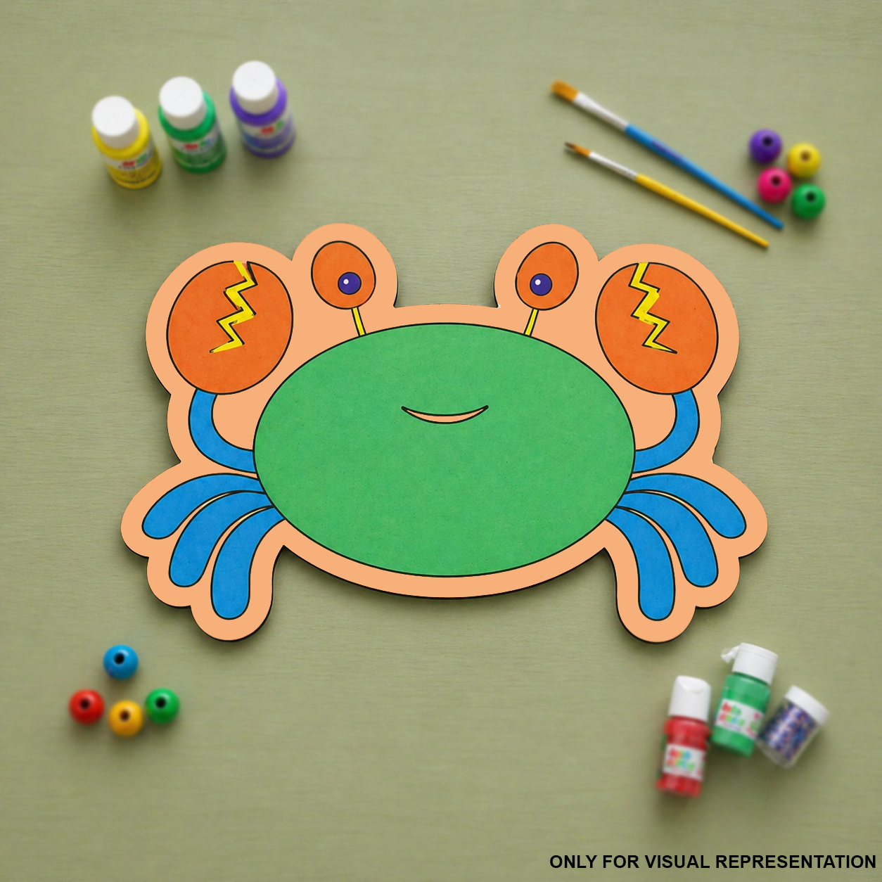 Colorful MDF DIY crab craft with painting supplies on a green background