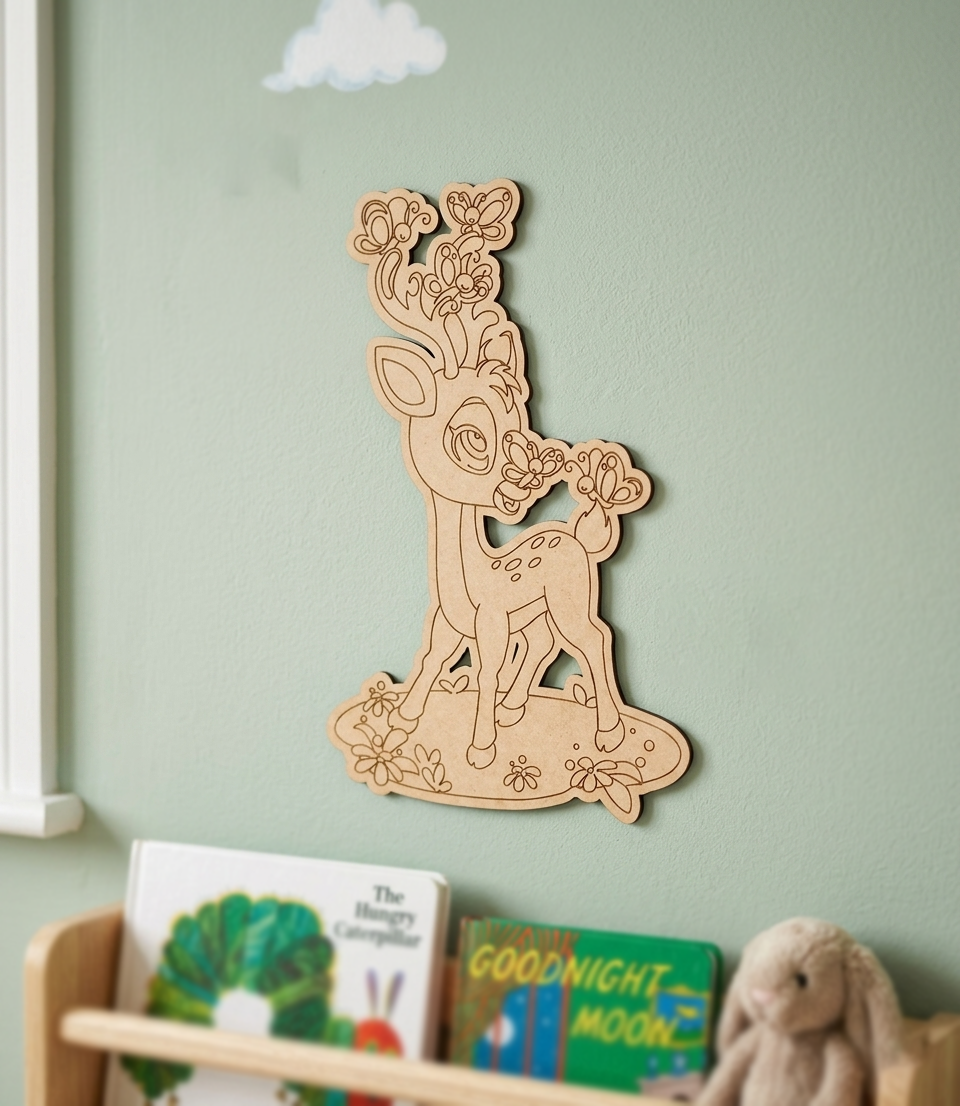 MDF DIY deer wall decoration on a light green wall with children's books and a plush toy below.