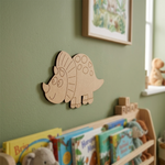 MDF DIY turtle decoration on a green wall above children's books and toys.