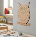 MDF DIY owl cutout hanging on grey wall.