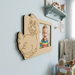 MDF DIY  duck-shaped frame with a photo of a child on a light blue wall in a nursery.