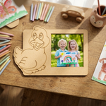 MDF DIY  duck-shaped picture frame with a photo of two children holding a rainbow drawing on a wooden table.