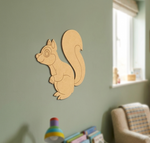 MDF DIY squirrel wall decoration on a light green wall with a chair and toys in the background.