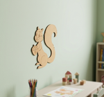 MDF DIY squirrel wall decoration on a light green wall with a child's desk and toys in the background.