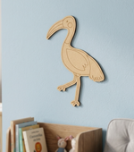MDF DIY  bird-shaped decoration on a light blue wall with books and a toy in the foreground.