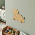 MDF DIY  turtle decoration on a light green wall with toys below