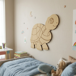 MDF DIY  turtle wall decoration in a child's bedroom with books and toys on a bed.