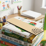 Stack of children's books with a MDF DIY bookmark on a table in a classroom setting.