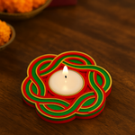 Decorative candle holder with a lit candle on a wooden surface