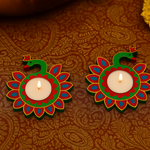 Two colorful candle holders with flames on a patterned fabric background