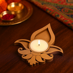 Decorative mdf candle holder with a lit candle on a wooden surface.