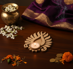 Decorative setup with a mdf tealight candle holder, flowers, and coins on a wooden surface.