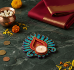 Decorative mdf candle holder with a lit candle on a dark surface with marigold flowers and coins.
