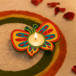 Butterfly-shaped mdf candle holder with a lit candle on a decorative surface.