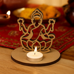 MDF Laxmi ji deity figure with a candle on a wooden surface