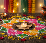 Colorful rangoli design with a lit candle on a dark surface, surrounded by decorative elements.
