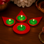 Red and green Diwali candles on a wooden surface with decorative elements.