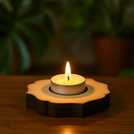 Candle in a decorative MDF Candle holder on a wooden surface with a blurred green background
