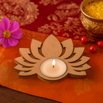 MDF lotus-shaped candle holder with a lit candle on an orange fabric background.