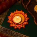 Decorative candle holder with a lit candle on a dark surface