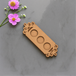 MDF floral border t-light holder with three empty slots on marble surface with flowers