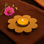 Flower-shaped candle holder with a lit candle on a brown fabric background