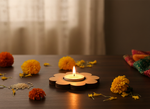 Decorative candle with marigold flowers on a wooden surface